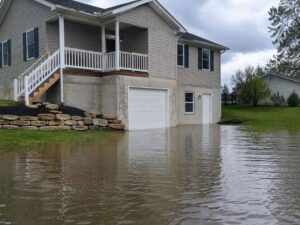 Raised suburban home near floodwater showing how elevation can affect flood insurance costs